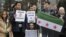 Demonstrators holding a Free Syria flag and placards reading "Stop the killing in Syria" take part in a protest outside the United Nations (UN) offices in Geneva, on Jan. 29, 2016 on the opening day of Syrian peace talks.