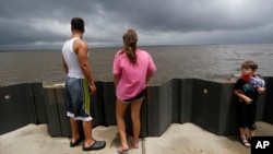 Jonas Cheramie (left) and his sister Lainey Cheramie, watch storm clouds from Tropical Storm Cindy, as they babysit A.J. Aaron, 5, in Lafitte, La., June 21, 2017.