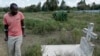 FILE—John Muchiri Kamunge, brother-in-law to Agnes Wanjiru, 20, who was allegedly killed by a British soldier in 2012, visits her grave at a cemetery in Nanyuki, Kenya, November 4, 2021. 