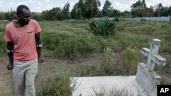 FILE—John Muchiri Kamunge, brother-in-law to Agnes Wanjiru, 20, who was allegedly killed by a British soldier in 2012, visits her grave at a cemetery in Nanyuki, Kenya, November 4, 2021. 