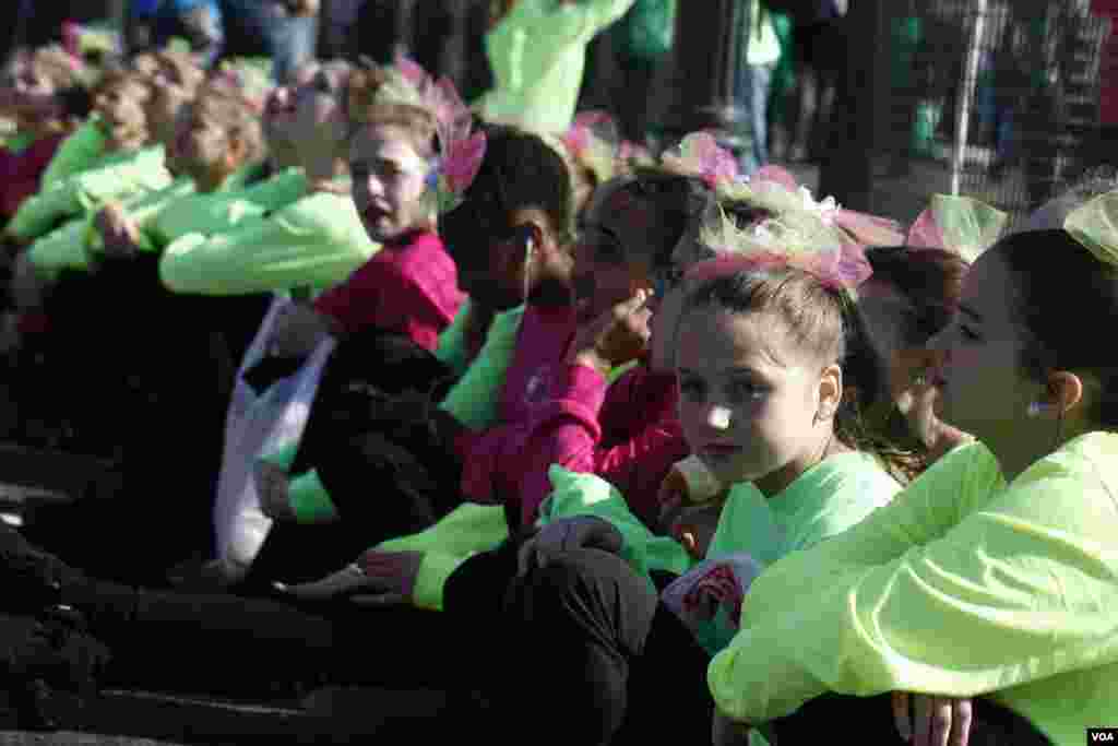 Các bé gái ngồi nghỉ trước khi cuộc diễu hành bắt đầu.