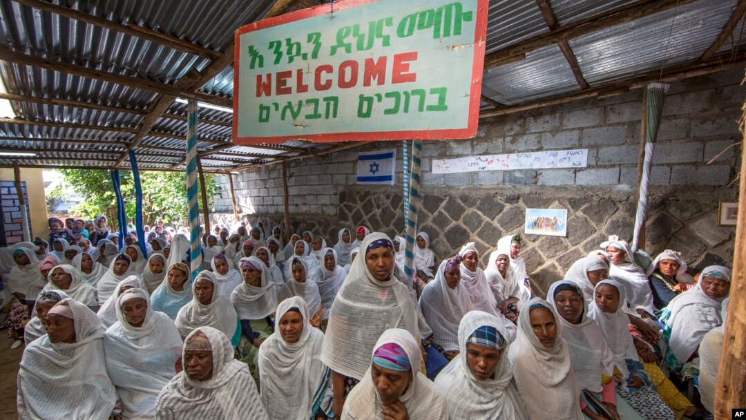 Members of Ethiopia's Jewish community gather below a banner reading "Welcome" in Amharic, English and Hebrew, to protest the Israeli decision not to allow all of them to emigrate to Israel, leaving their families divided between the two countries, in Addis Ababa, Nov. 19, 2018. 