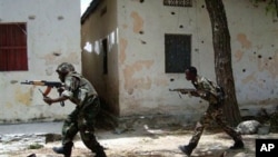 Somali government forces run in a street during skirmishes with insurgents from the al-Qaida aligned terrorist group Al-Shabaab in the Wardigley neighborhood in Mogadishu, Somalia, Monday, Sept. 27, 2010. (AP Photo/ Mohamed Sheikh Nor)