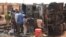 Residents look at a calcined tanker truck after an explosion which killed more than 55 people near the airport of Niamey, May 6, 2019. 