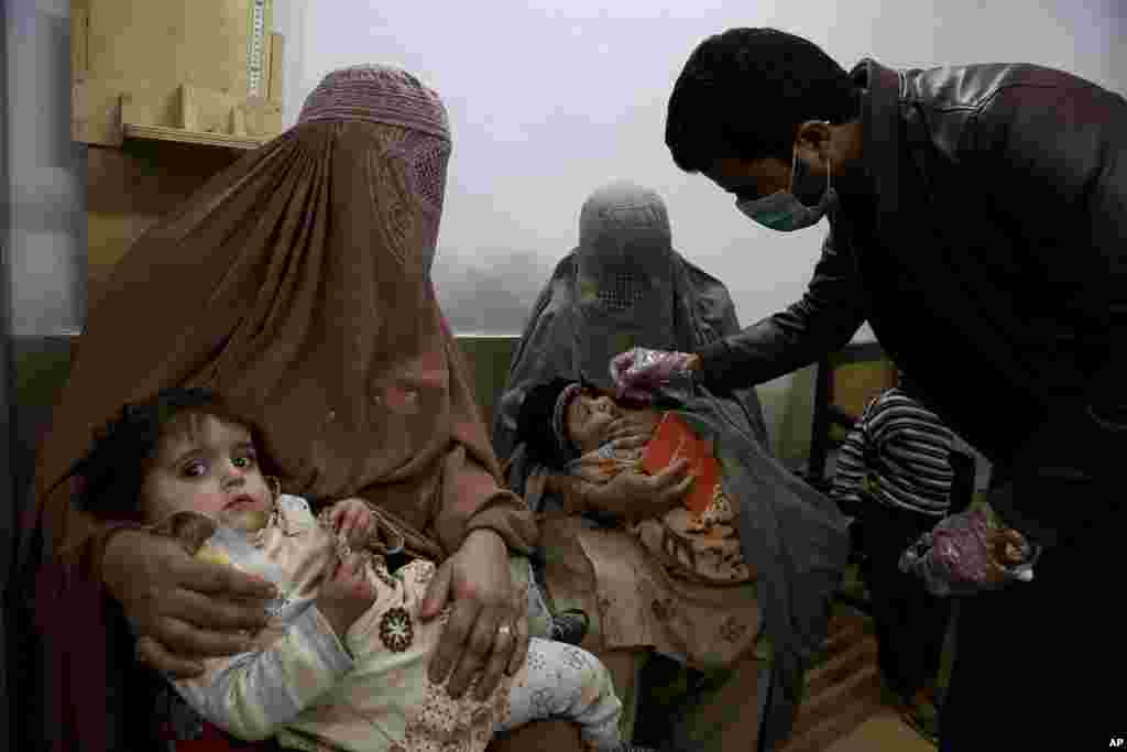 A health care worker administers a polio vaccine to a child at a clinic, in Peshawar, Pakistan.