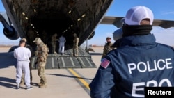 ARCHIVO - Primer avión militar de EEUU que transporta a inmigrantes detenidos a un centro de detención en la Bahía de Guantánamo, considerados como "extranjeros criminales altamente peligrosos", es abordado desde un lugar no especificado en Estados Unidos el 4 de febrero de 2025.