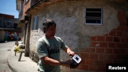 FILE - A technician releases Aedes aegypti mosquitoes with the dengue-blocking Wolbachia bacteria at the Tubiacanga neighborhood in Rio de Janeiro, Sept. 24, 2014.
