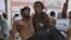A Pakistani mine worker carries an injured colleague at a hospital in Quetta, Pakistan, May 5, 2018. A government official says a methane gas explosion in a coal mine has killed 23 miners in southwest Pakistan.