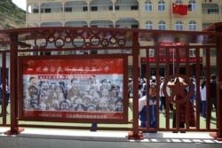 FILE - A picture of Chinese President Xi Jinping is seen at a primary school near Yangjialing Revolutionary Site, in Yanan, Shaanxi province, China, May 10, 2021.