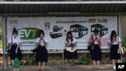 Students from Chulalongkorn University wear face masks to protect themselves from poor air quality as they wait at a bus stop in Bangkok, Thailand, Monday, Jan. 20, 2020. Thick haze blanketed the Thai capital on Monday sending air pollution levels…