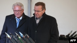 FILES - CEO of Rheinmetall Armin Papperger and German Defense Minister Boris Pistorius look at ammunition at the future site of a factory in Unterluess, Germany, Feb. 12, 2024. CNN reported on July 11, 2024, that Papperger was the target of an alleged Russian assassination plot.