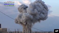 FILE - An image by Syrian activists purports to show smoke rising after a Russian airstrike hit buildings in the town of Latamna, near Hama in eastern Syria, Oct. 7, 2015.