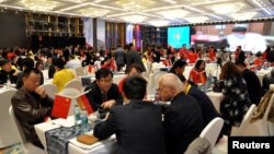 FILE - Local businessmen and foreign investors negotiate at a cross-border investment and trade fair in Guiyang, Guizhou Province, China, Nov. 10, 2016. 