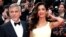 FILE - George Clooney and his wife, Amal, pose on the red carpet during the 69th Cannes Film Festival in Cannes, France, May 12, 2016.