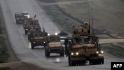 FILE - A convoy of US military vehicles is seen in Syria's northern city of Manbij, Dec. 30, 2018.