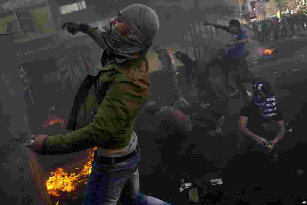 Palestinians clash with Israeli forces, not pictured, in the West Bank city of Hebron, April 4, 2013.