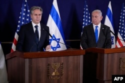 FILE - Israeli Prime Minister Benjamin Netanyahu (R) looks on as US Secretary of State Antony Blinken gives statements to the media inside The Kirya, which houses the Israeli Defence Ministry, after their meeting in Tel Aviv on October 12, 2023.