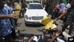 Protester lays down outside Kenyan Parliament to block legislators from leaving, Nairobi, Oct. 9, 2012.