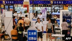 Foto del 19 de agosto de 2023 muestra a los asistentes a una feria de empleos en Beijing.