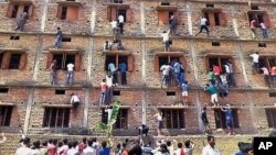 Sejumlah warga memanjat dinding bangunan untuk membantu para siswa menempuh ujian di Hajipur, negara bagian Bihar, India, 18 Maret 2015 (AP Photo/Press Trust of India, File).