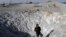 A Palestinian militant inspects a crater caused by what police said was an Israeli air strike in Khan Younis in the southern Gaza Strip, June 29, 2014. 