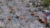 Muslim pilgrims pray the noon prayers near fruit carts in Arafat, near the holy city of Mecca, Saudi Arabia, Oct. 14, 2013. 