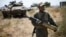 An Israeli soldier carries a tank shell near Alonei Habashan on the Israeli occupied Golan Heights, close to the ceasefire line between Israel and Syria June 22, 2014. 