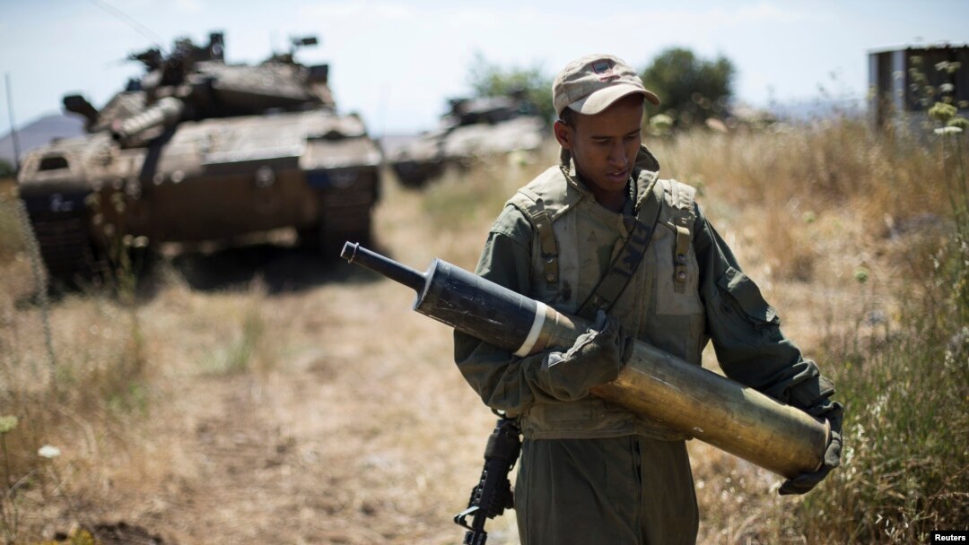 Seorang tentara Israel membawa persenjataan di dekat Alonei Habashan di Dataran Tinggi Golan yang dikuasai oleh Israel, dekat garis pertempuran antara Israel dan Suriah (22/6). 