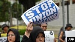 Seorang aktivis perempuan membawa poster saat demo di Jakarta, 10 Desember 2019. (Foto: AFP)