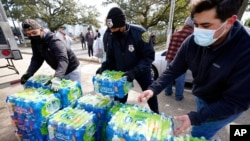 Donated water is distributed to residents, Feb. 18, 2021, in Houston. The city and several surrounding cities were under a boil water notice as many residents were still without running water in their homes. 