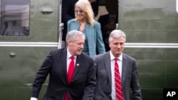 FILE - Mark Meadows, left, Robert O'Brien and Kellyanne Conway step off Marine One, March 28, 2020, in Washington. The three were named in a watchdog report that found 13 Trump administration members had willfully violated the Hatch Act.