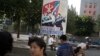 FILE - A man sits under a propaganda banner in Pyongyang, North Korea, Aug. 23, 2015. 