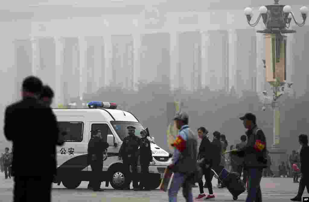 雾霾中的天安门广场上，警察也带口罩。（2014年10月20日）