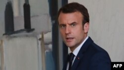 FILE - French President Emmanuel Macron (R) leaves after a meeting with the Senegalese President at the Elysee Palace in Paris, April 20, 2018. 