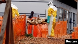 FILE PHOTO: Health workers carry a newly admitted confirmed Ebola patient into a treatment center in Butembo in the eastern Democratic Republic of Congo, March 28, 2019.