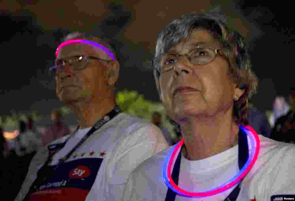 Richard and Carol Smith look at the broadcast screen showing Republican presidential nominee Mitt Romney and U.S. President Barack Obama during the final U.S. presidential debate in Boca Raton, Florida, October 22, 2012. 