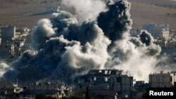 An explosion following an air strike is seen in central Kobani, Nov. 9, 2014. Picture taken from the Turkish side of the Turkish-Syrian border.