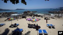 Turis berlibur di Pantai Patong di provinsi Phuket, Thailand selatan. Laut yang berwarna biru, taman-taman satwa liar, makanan lezat dan distrik merahnya menarik banyak turis datang ke Thailand selama berpuluh-puluh tahun. (Foto: dok.)