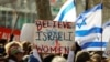 资料照片：在纽约联合国总部外抗议的示威者手举“相信以色列妇女”的标语。（2023年12月4日）