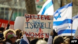 资料照片：在纽约联合国总部外抗议的示威者手举“相信以色列妇女”的标语。（2023年12月4日）