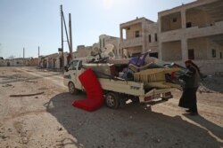 A man loads his belongings into a truck as he prepares to flee the village of al-Nayrab, about 14 kilometers southeast of the city of Idlib in northwestern Syria, on March 7, 2020.