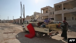 A man loads his belongings onto a truck as he prepares to flee the village of al-Nayrab, about 14 kilometers southeast of the city of Idlib in northwestern Syria, March 7, 2020.