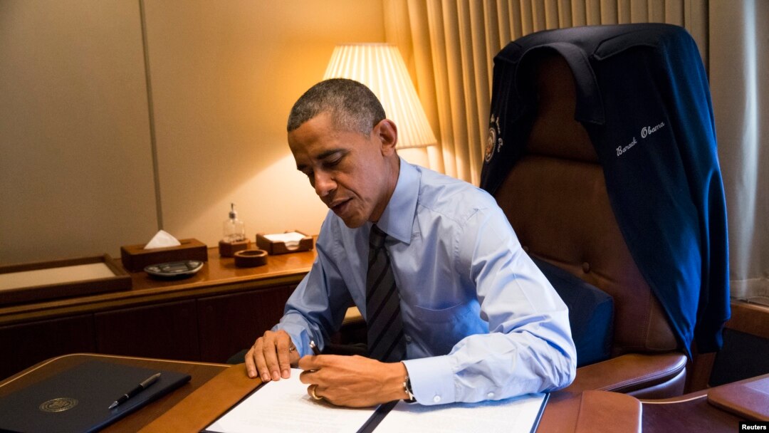 Presiden Obama menandatangani dua perintah eksekutif terkait imigrasi di ruang kerjanya dalam pesawat kepresidenan Air Force One (21/11).