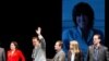 George C. Wolfe , Maura Tierney, and Tom Hanks, with an image of Nora Ephron behind them on a large screen, at the "Lucky Guy" opening night, April, 1, 2013 in New York, NY. 