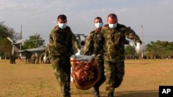 Foto de archivo de soldados que llevan el cuerpo de un supuesto rebelde de izquierda, en una base militar en Tame, en el estado colombiano de Arauca.