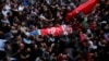 Palestinian mourners carry the body of Omar Badawi, 22, during his funeral at the al-Arroub refugee camp in the West Bank city of Hebron, Nov. 11, 2019.