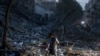 EDITORS NOTE: Graphic content / TOPSHOT - A man walks atop the rubble of a tower destroyed in an Israeli air stike in Gaza City on October 7, 2023.