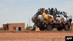 Warga menaiki truk melewati pos pemeriksaan setelah serangan ektremis di Niamey, Niger, 19 Juni 2019. (Foto: AFP)