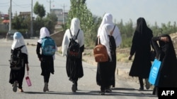 FILE - Afghan girls walk to their school in Gardez on Sept. 8, 2022. A Taliban official said on March 12, 2024, that the Taliban may permanently close girls' secondary schools, which already had been shut down in 2022.