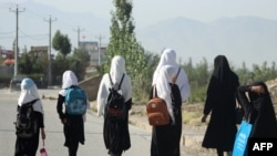 FILE - Afghan girls walk to their school along a road in Gardez, Paktia province, on Sept. 8, 2022. Before the Taliban’s takeover of Afghanistan, about 3.5 million girls out of roughly 9 million students were going to school.